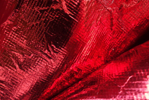 Textura de película de polietileno rojo de plástico plegado - Foto, Imagen