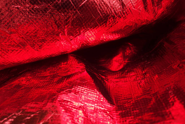 Textura de película de polietileno rojo de plástico plegado - Foto, Imagen