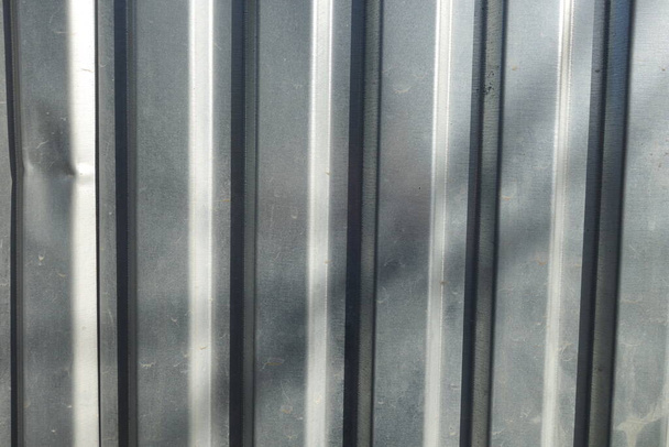 Κυματοειδές μεταλλικό φύλλο χρησιμεύει ως φράχτης, θέα οριζόντια προς κάθετες λωρίδες - Φωτογραφία, εικόνα