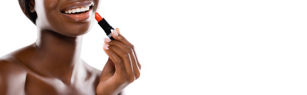 bijgesneden beeld van Afrikaans Amerikaanse naakte vrouw het aanbrengen van lippenstift geïsoleerd op wit, panoramisch schot - Foto, afbeelding