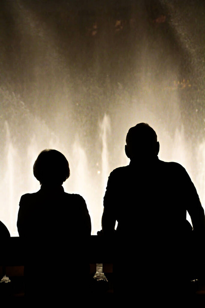 ラスベガスでのベラジオ噴水の光景を賞賛する人々のシルエットと夜のシーン - 写真・画像