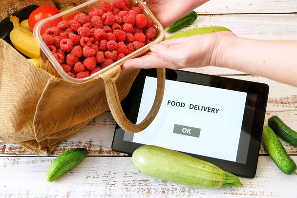 Verduras orgánicas y frutas en bolsa de algodón y teléfono móvil con espacio para copiar, mercado en línea, entrega de comestibles verdes en el concepto de casa, comprar concepto en línea - Foto, imagen