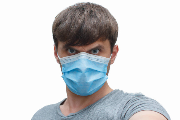 the man in the mask-protection from the coronavirus. a man wears a protective face mask at home. Stop the virus and epidemic diseases. - Foto, Imagem