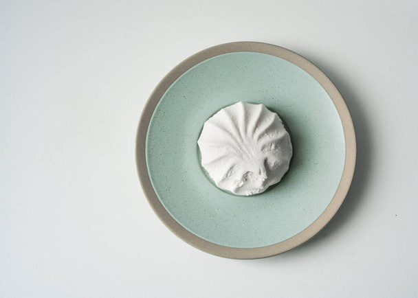 minta fehér zefir zöld tányéron, minimalista háttér, édes cukorka - Fotó, kép