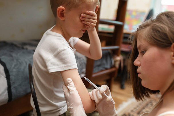 Niño con miedo a la inyección de vacunas en el brazo. - Foto, Imagen