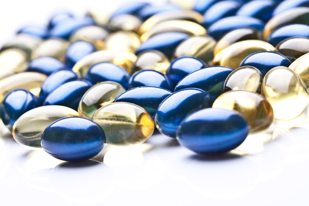 Värikäs vitamiini geeli kapselit eristetty whiteback maahan
 - Valokuva, kuva