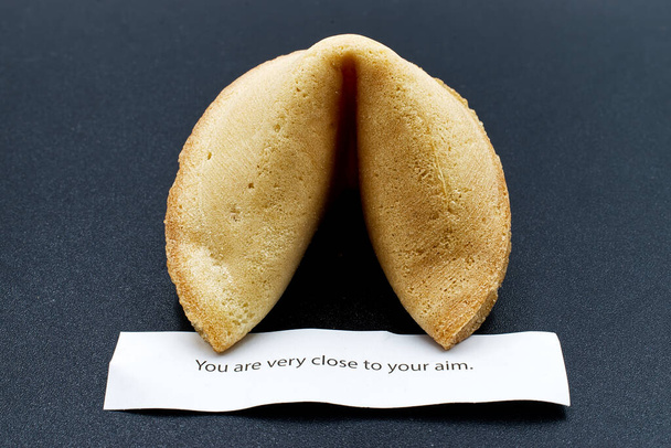 Chinese fortune cookie isolated on dark background - Photo, Image
