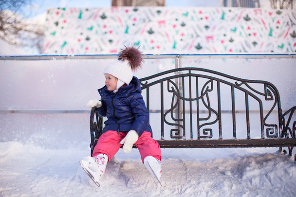 buz pateni pisti, bir bankta oturan kız - Fotoğraf, Görsel