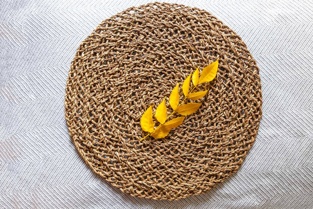 Branch with yellow leaves on the round wicker diy with copy space - 写真・画像