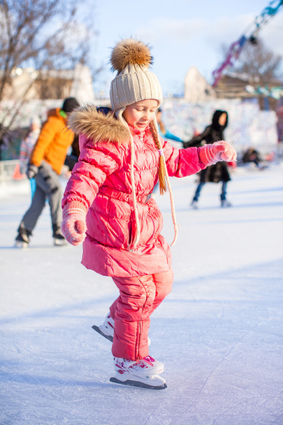 Menina encantadora gosta de patinar na pista de gelo
 - Foto, Imagem