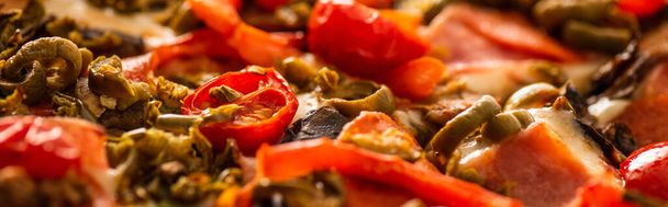 close-up uitzicht op heerlijke Italiaanse pizza met groenten en salami, panoramisch schot - Foto, afbeelding