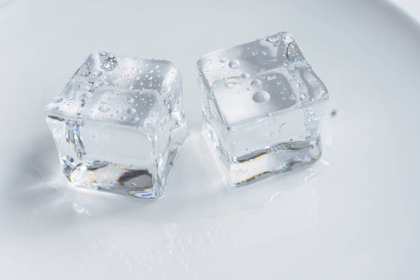 Cubi di ghiaccio trasparenti isolati in colore grigio, sfondo bianco, cristallo - Foto, immagini