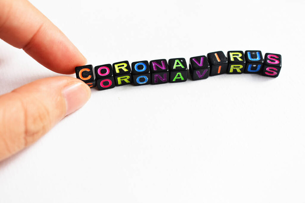 "Hintergrund ist das Coronavirus. Word Coronavirus mit schwarzen Blöcken, Würfel auf weißem Hintergrund, Würfel in Regenbogenfarbe - Foto, Bild