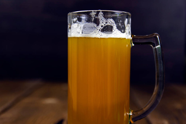 Glas koud ongefilterd dik licht bier op rustieke houten tafel - Foto, afbeelding