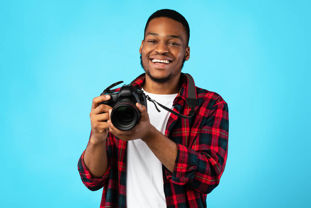 Black Photographer Guy Holding Camera Posing On Blue Background - Φωτογραφία, εικόνα