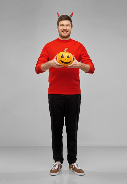 happy man in halloween costume of devil over grey - Foto, imagen