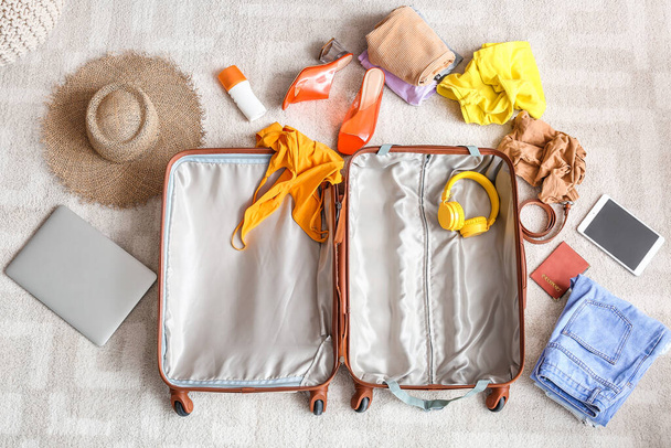 Suitcase with beach accessories on floor. Travel concept - Photo, Image