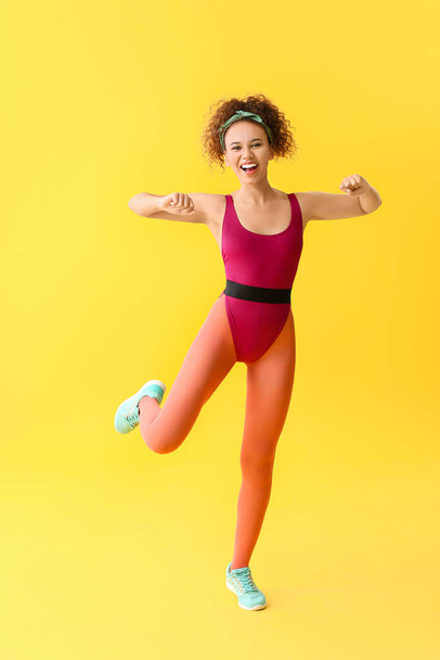 Young woman doing aerobics on color background - Foto, Bild