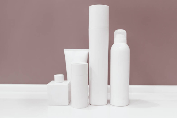 Mock up white Bottles and Dropper Set purple Background. Cosmetic cream containers and tubes for cream, lotion, shampoo, gel, balsam, conditioner, spray. on the shelf in bathroom - Foto, afbeelding