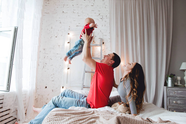 boldog szülők baba fiú az ágyban - Fotó, kép