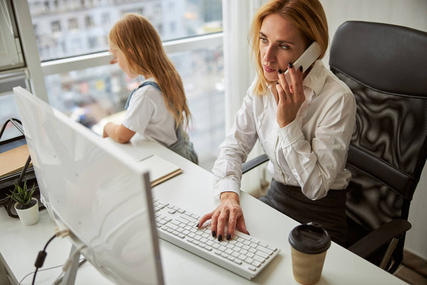 Розумна бізнес-леді сидить за робочим столом
 - Фото, зображення