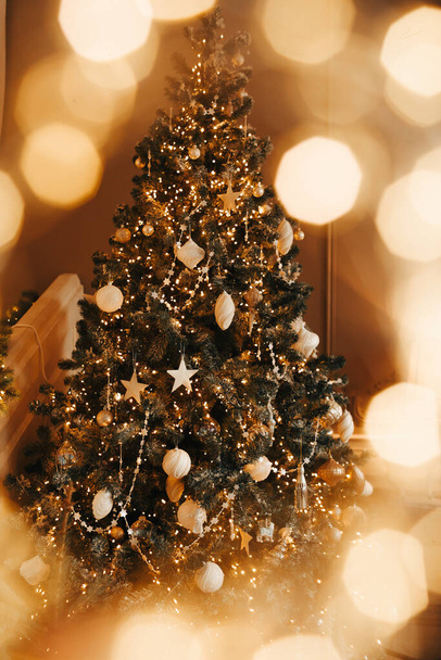 Luxus gemütliche und warme Weihnachtszimmer Inneneinrichtung, Weihnachtsbaum geschmückt mit Lichtern Geschenke Spielzeug, Kerzen, Laternen, Girlanden Beleuchtung Kamin, Urlaub Wohnzimmer. - Foto, Bild