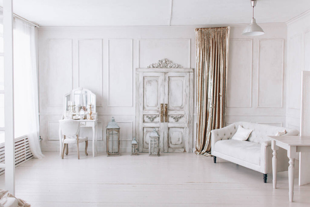 krásný bílý interiér, klasický pokoj s dřevěnou podlahou a dveřmi, světlá stěna s lišty, židle toaletní stolek se zrcadlem - Fotografie, Obrázek