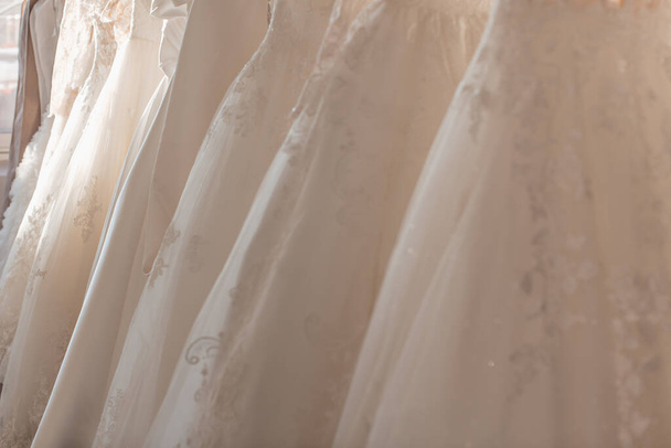 beautiful white wedding dresses on hangers in the store - Photo, Image