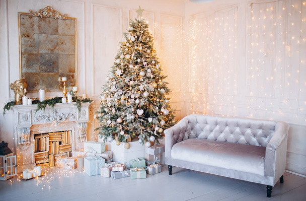 warm cozy beautiful modern design of the room in delicate light colors decorated with Christmas tree and decorative elements fireplace - Foto, Imagem