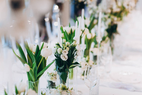 Nahaufnahme eines eleganten Hochzeitstisches mit weißen Blumen - Foto, Bild