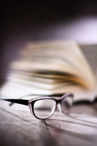 Composition with glasses and open book on the table. - Photo, Image