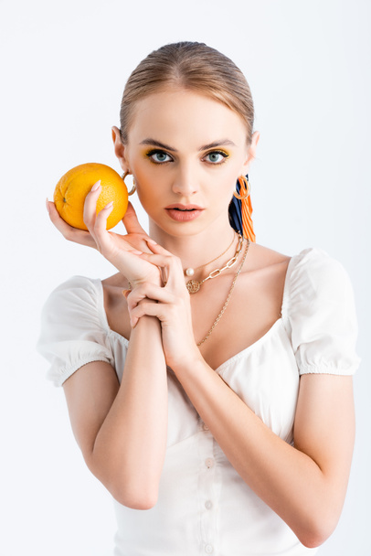 elegant blonde woman posing with orange isolated on white - Fotó, kép