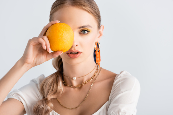 elegant blonde woman with obscure face posing with orange isolated on white - Fotó, kép
