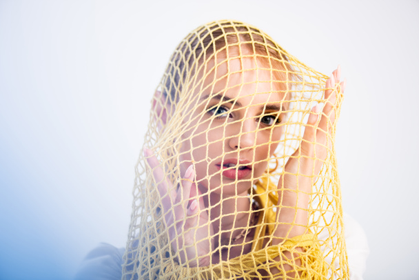 woman posing in yellow string bag on white background - Foto, imagen