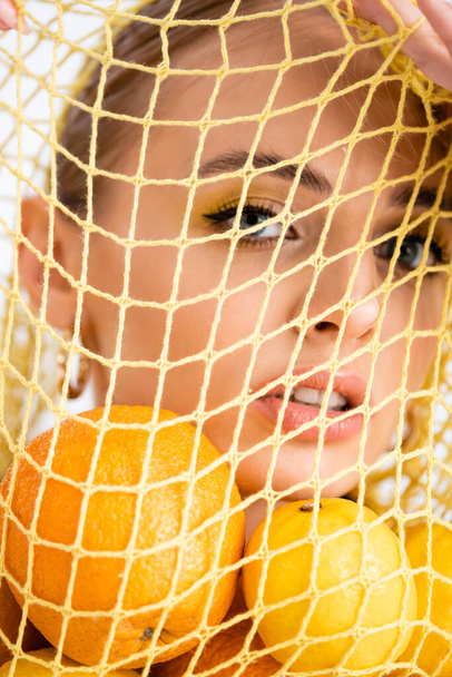 portré egy nő húrzacskóban citrusfélékkel - Fotó, kép