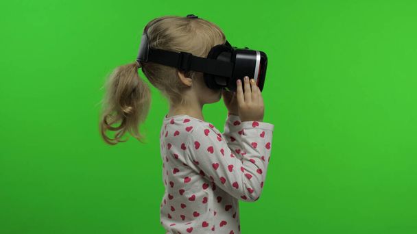 Gyermek lány használ VR headset sisak játszani játék. Virtuális valóság megtekintése 3d 360 videó. Kroma kulcs - Fotó, kép