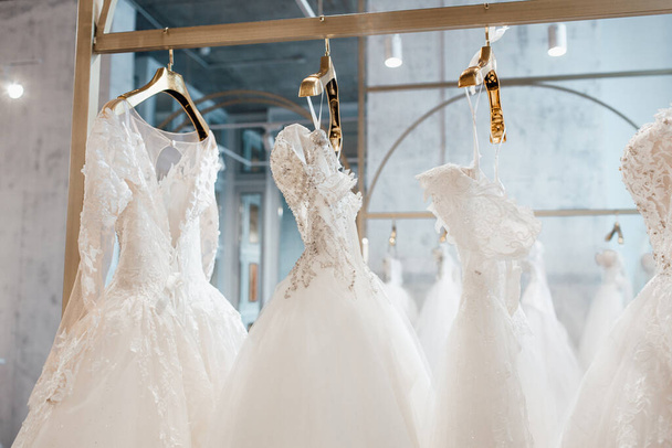 beautiful white wedding dresses on hangers in the store - Photo, Image