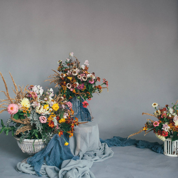 värikäs kukkakimppuja kuivattuja kukkia harmaalla kankaalla tausta - Valokuva, kuva