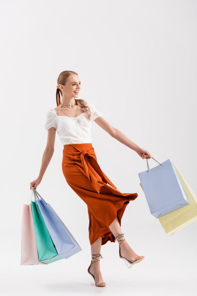 full length view of elegant woman walking with shopping bags on white - Fotoğraf, Görsel