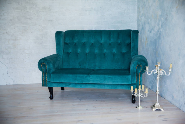 Velvet turquoise sofa on the background of a grunge wall - Foto, Imagem