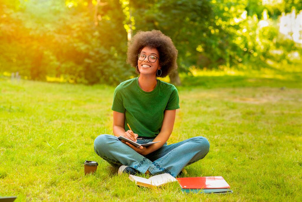 Πορτρέτο του μαύρου χαρούμενα κολέγιο φοιτητής κορίτσι απόσπαση, ενώ σπουδάζουν σε εξωτερικούς χώρους - Φωτογραφία, εικόνα