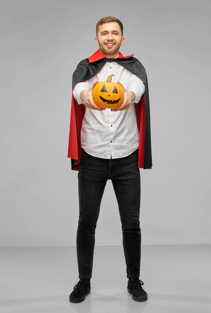man in halloween costume of vampire with pumpkin - Foto, immagini