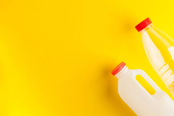 Merkityksetön biohajoava muovi maitopullot keltaisella pohjalla. Maitotuotteiden käsite. Ei tuhlausta. Kopioi tilaa. Laadukas kuva - Valokuva, kuva