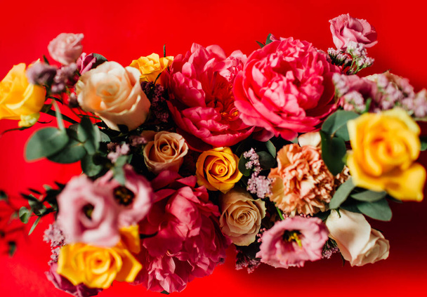 όμορφο μπουκέτο με πολύχρωμα λουλούδια σε κόκκινο φόντο - Φωτογραφία, εικόνα