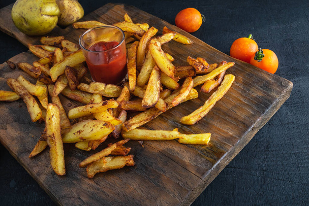 Frisse frietjes met ketchup op houten ondergrond - Foto, afbeelding