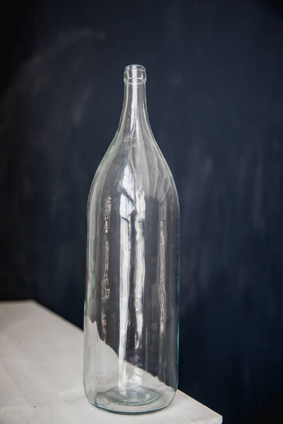 empty glass bottle on black background - Фото, изображение