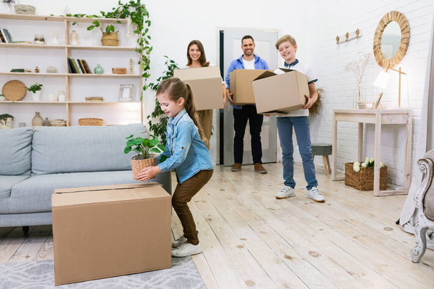 Caixas de embalagem da família movendo-se para novo apartamento em pé dentro de casa
 - Foto, Imagem