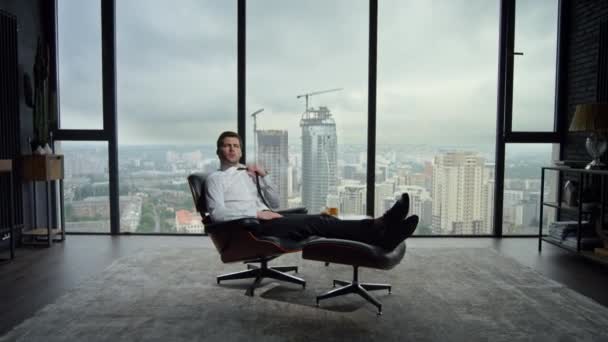 Επιχειρηματίας κάθεται σε καρέκλα στο σύγχρονο εσωτερικό. Επαγγελματική γραβάτα προσαρμογής - Πλάνα, βίντεο