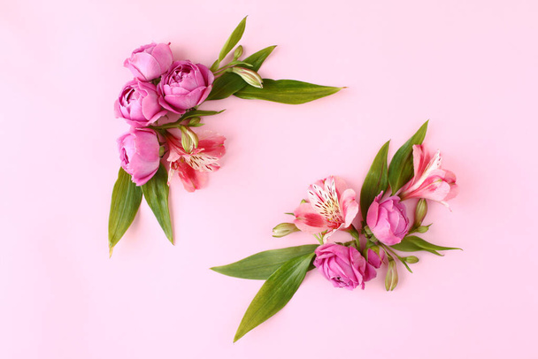 Rose buds frame on pink background. Flat lay, top view floral greetings concept. - Photo, image