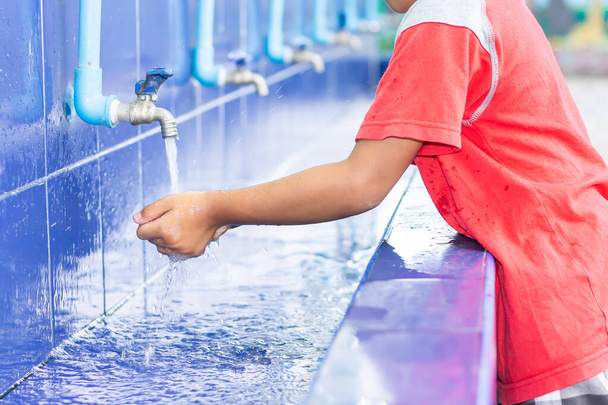 Υγειονομική περίθαλψη και παιδική μέριμνα. Ασιάτης παιδί αγόρι πλένει τα χέρια του πριν από το φαγητό και μετά παίζουν τα παιχνίδια στο μπολ πλύσιμο. Ένα αγόρι ηλικίας 5 ετών. - Φωτογραφία, εικόνα